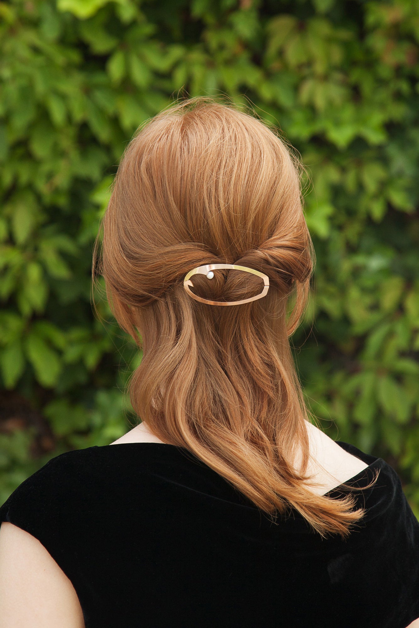 Model wearing a half updo styled with designer barrette ELSA by Clinq in gold-plated with a pearl 