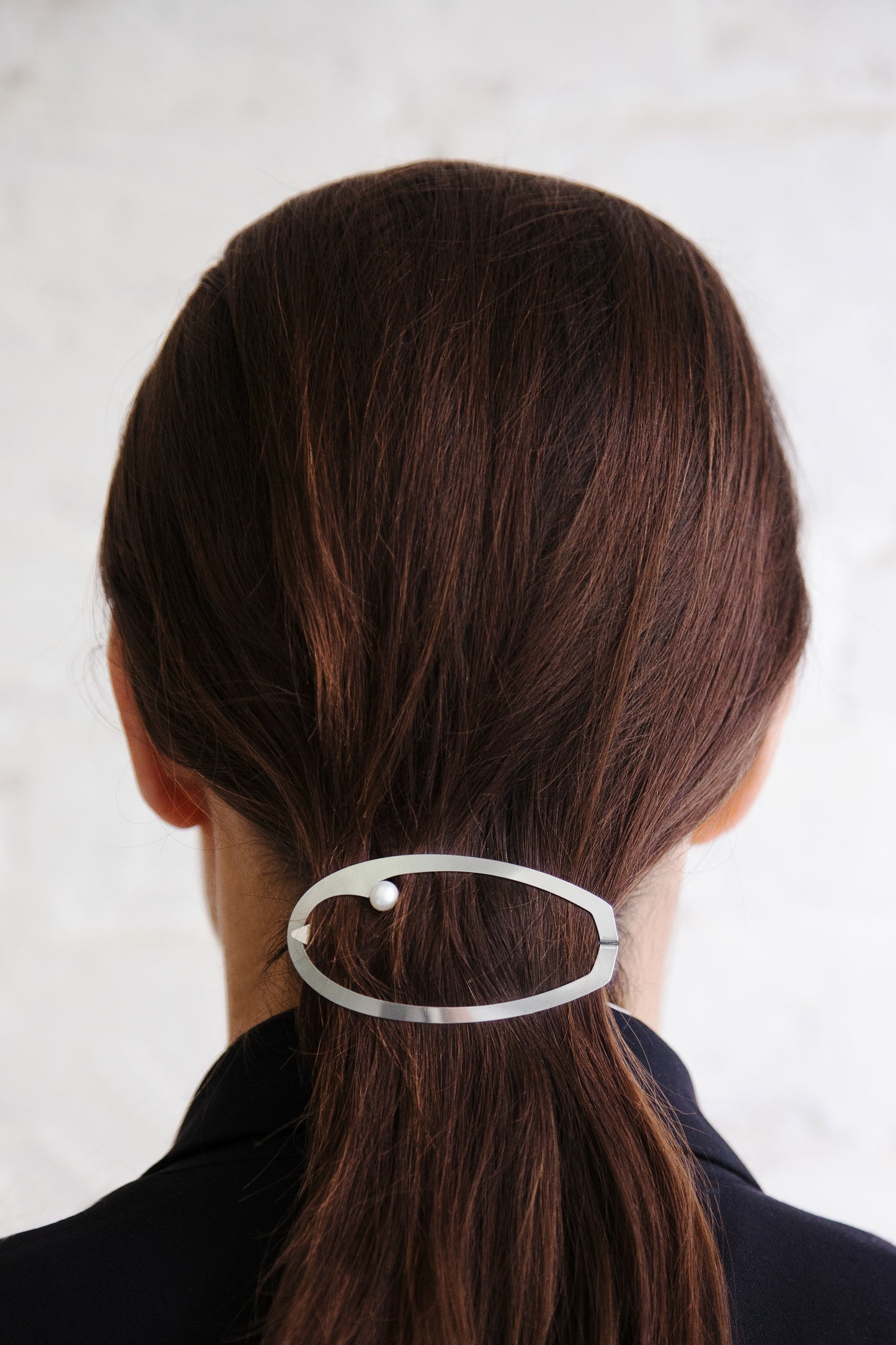 Back view of model wearing her hair in a low ponytail secured with designer barrette Elsa by Clinq 